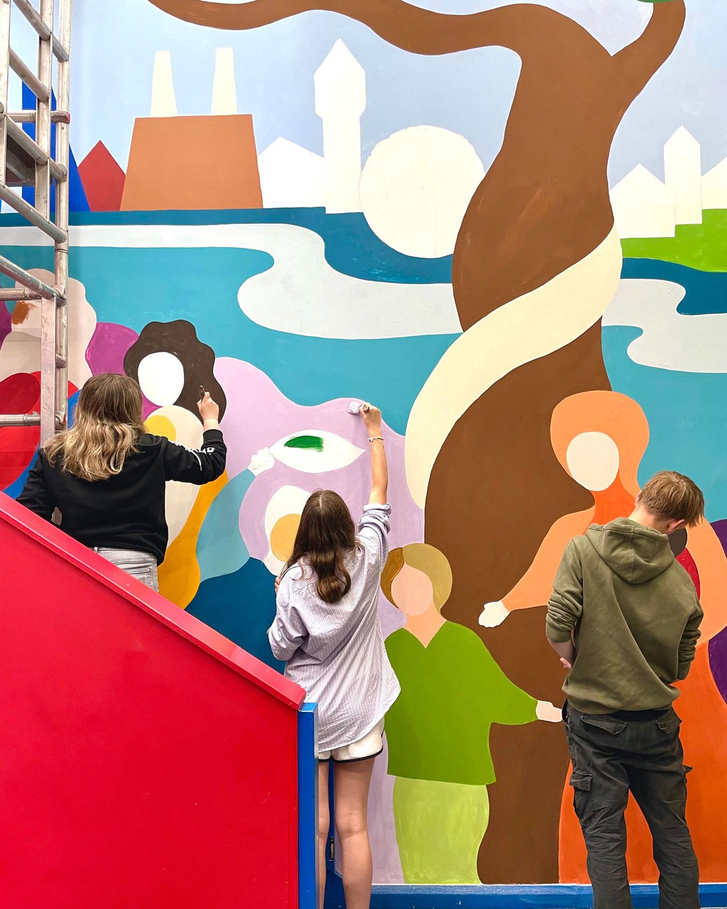Volunteers working on a colorful mural
