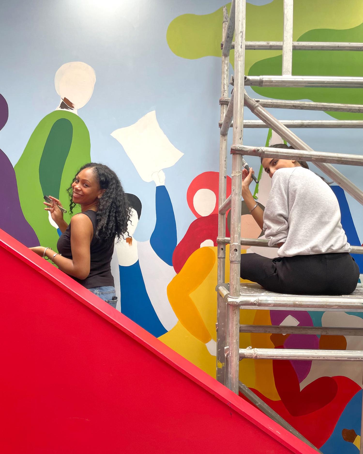 Volunteers working on a colorful mural